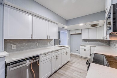 Kitchen with white cabinetry, dishwasher, sink, an