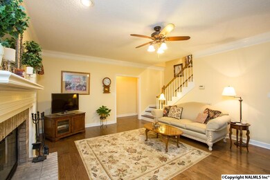 Warm and inviting living area with cozy fireplace, beautiful wood floors and  large windows to let nature views embrace you!