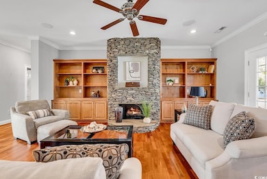 Living room with crown molding, a ceiling fan, vis