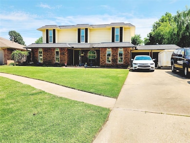 house with concrete driveway, a front lawn, brick siding, and a garage