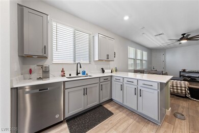 Kitchen featuring dishwasher, gray cabinets, a sin