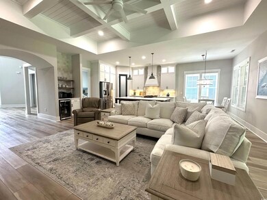 Living room featuring beamed ceiling, light wood-t