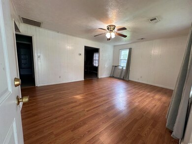 Empty room featuring wooden walls, dark wood-type 