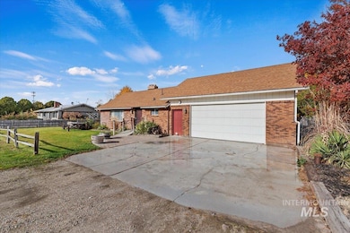 Ranch-style home with brick siding, concrete driveway, a chimney, an attached garage, and roof with shingles