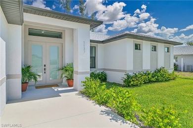 Property entrance featuring a yard and french door