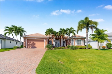 Front view of home featuring a front lawn, stucco siding, an attached garage, and decorative driveway