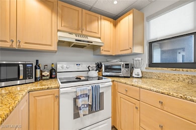 Kitchen with light stone countertops, light brown