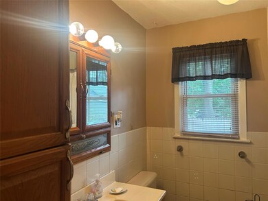 Bathroom featuring tile walls, vanity, and a wainscoted wall