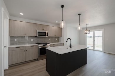 Kitchen featuring tasteful backsplash, light brown cabinets, appliances with stainless steel finishes, pendant lighting, and recessed lighting