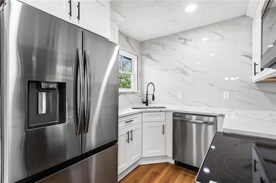 Kitchen with a sink, light stone counters, stainle