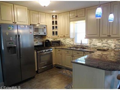 Kitchen. The kitchen was recently COMPLETELY upgraded with new glazed, soft close cabinetry,  granite counter tops, tile flooring, new light fixtures & stainless steel appliances, including a gas range.