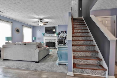 Living room featuring a tiled fireplace, hardwood 