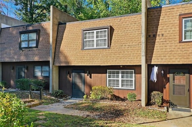 View of front of home featuring mansard roof and roof with shingles