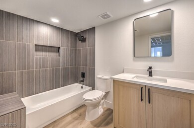 Bathroom featuring wood finished floors, vanity, t