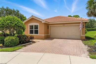View of front facade with stucco siding, decorative driveway, a garage, and a tile roof