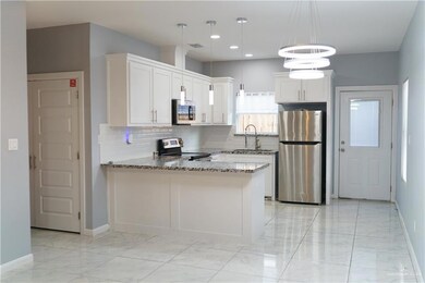 Kitchen featuring appliances with stainless steel finishes, light stone counters, light marble finish floors, tasteful backsplash, and recessed lighting