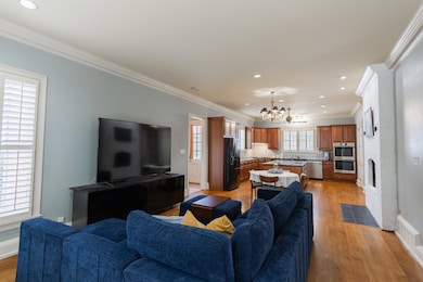 Living room with sink, crown molding, light wood-t