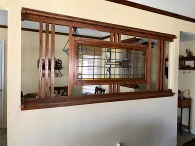 Living room separated from dining area by stained 