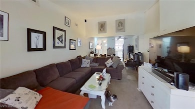 Living area with a towering ceiling and a ceiling fan