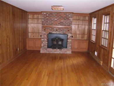 family room with woodstove with blower, hardwood a