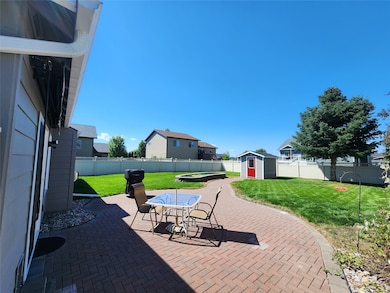 Fenced backyard with a patio area, outdoor dining area, and a storage shed