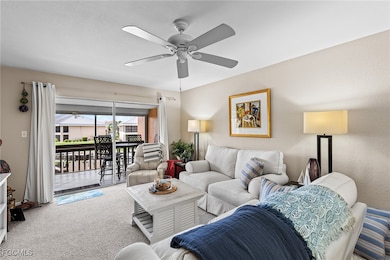 Carpeted living room featuring ceiling fan and a sunroom