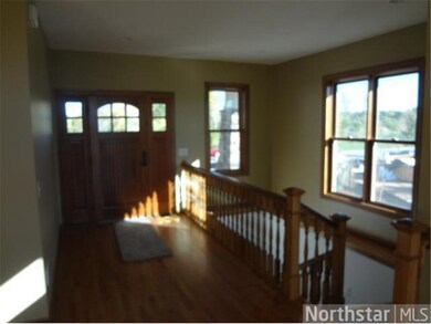 Bright cheery front entry with open staircase.