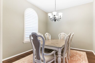 You and your guest will certainly dine in style in this amazing formal dining room! Featuring modern
chandelier, large arched window with plantation shutters, neutral paint, high ceilings, and dark
stained wood flooring!