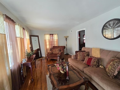 Living room with visible vents, wood finished floo