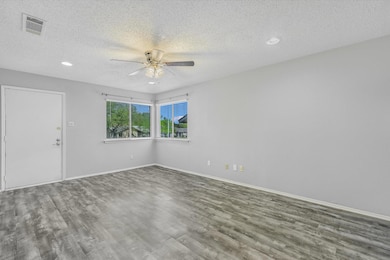 Unfurnished room featuring baseboards, a textured