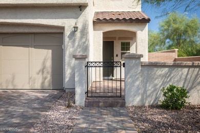 View of exterior entry featuring stucco siding, a garage, and a gate