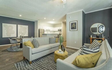 Living area featuring a textured ceiling, ornamental molding, dark wood finished floors, recessed lighting, and a ceiling fan