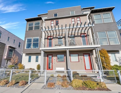 View of front of house featuring stucco siding, a balcony, a fenced front yard, and a gate