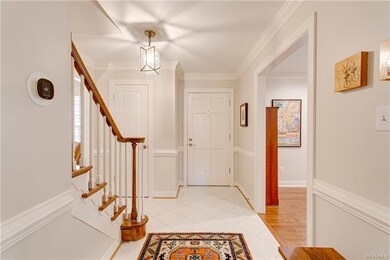 The welcoming Foyer has a tile floor, custom moldi