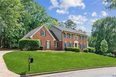 Colonial house featuring a front yard and brick siding