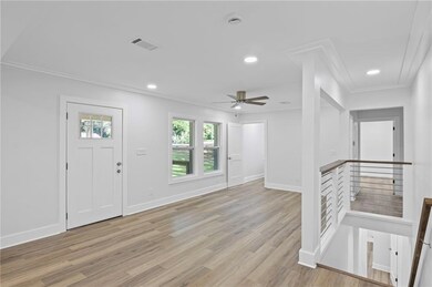 Foyer with light wood-style floors, ceiling fan, ornamental molding, and recessed lighting
