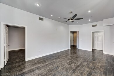 Unfurnished room with a ceiling fan, dark wood-typ