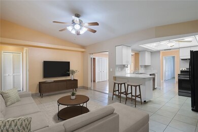 Tiled living room with vaulted ceiling with skylig