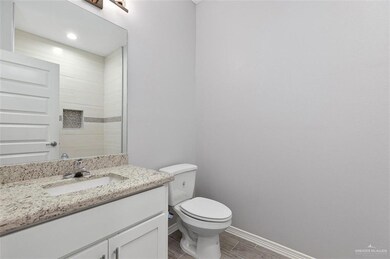 Bathroom with toilet, vanity, baseboards, and wood finish floors