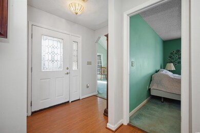 Foyer entrance featuring a textured ceiling, baseb