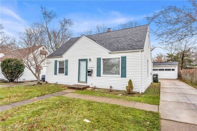 View of front of home with an outbuilding, a garage, and a front lawn