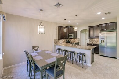 Tiled dining space with sink and an inviting chand