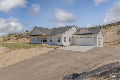 View of front of property with concrete driveway, an attached garage, roof with shingles, a front yard, and board and batten siding
