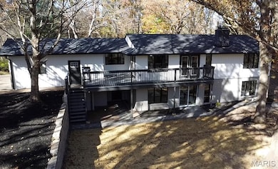 Back of property with a chimney, roof with shingles, and stairs