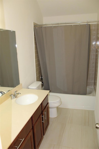 Full bath with toilet, shower / bath combo, and v