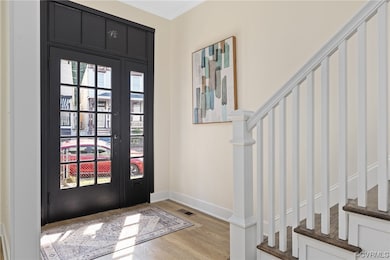 Entryway with crown molding and light hardwood flo