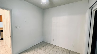 Unfurnished room featuring light tile patterned f