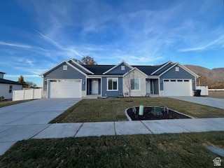 Ranch-style home with driveway, a garage, and stone siding