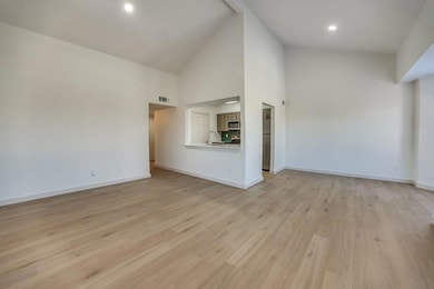 Unfurnished living room with sink, high vaulted ce