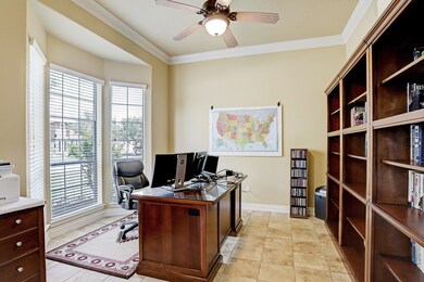 Study with bay windows, crown molding, and neutral